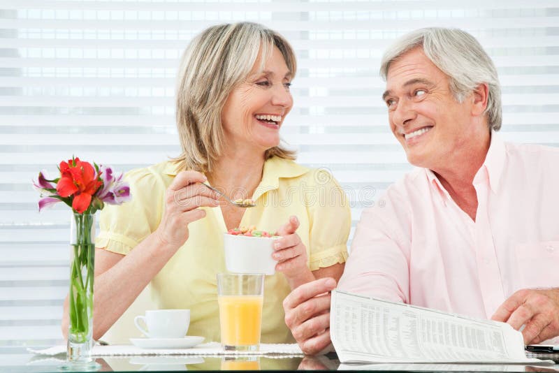 Happy smiling senior couple eating breakfast at home. Happy smiling senior couple eating breakfast at home