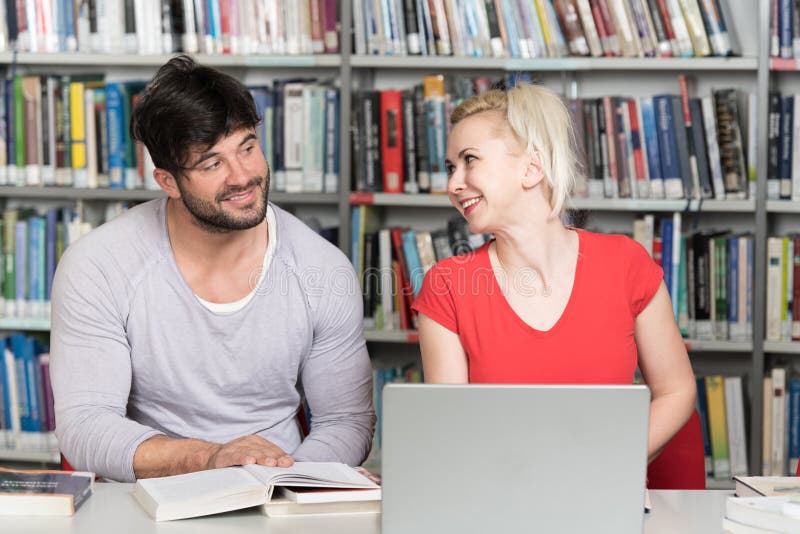 Para ucznie Z laptopem W bibliotece obraz stock Para ucznie Z laptopem W bibliotece obraz stock