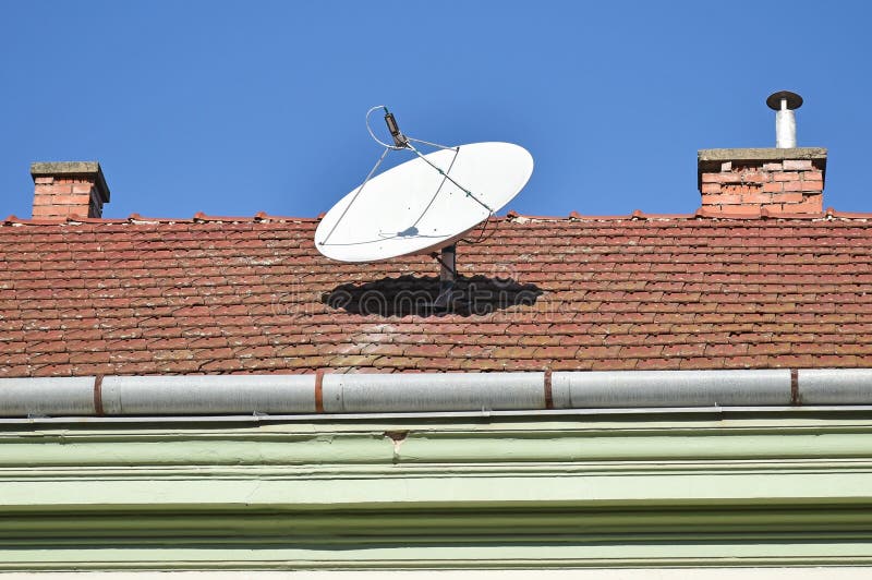Parabolic antenna on the roof of a house stock photo