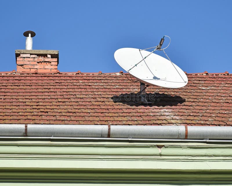 Parabolic antenna on the roof of a house stock photo