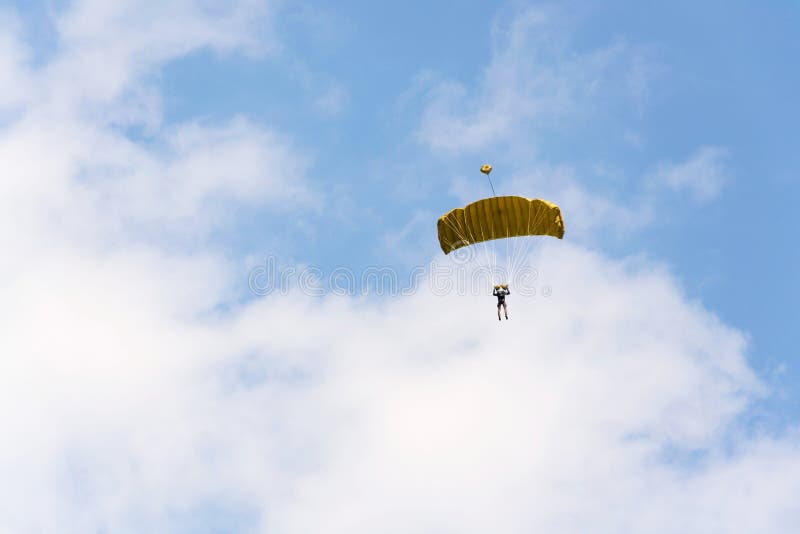 Parachutist Skydiving With Open Yellow Parachute Clouds Blue Sky