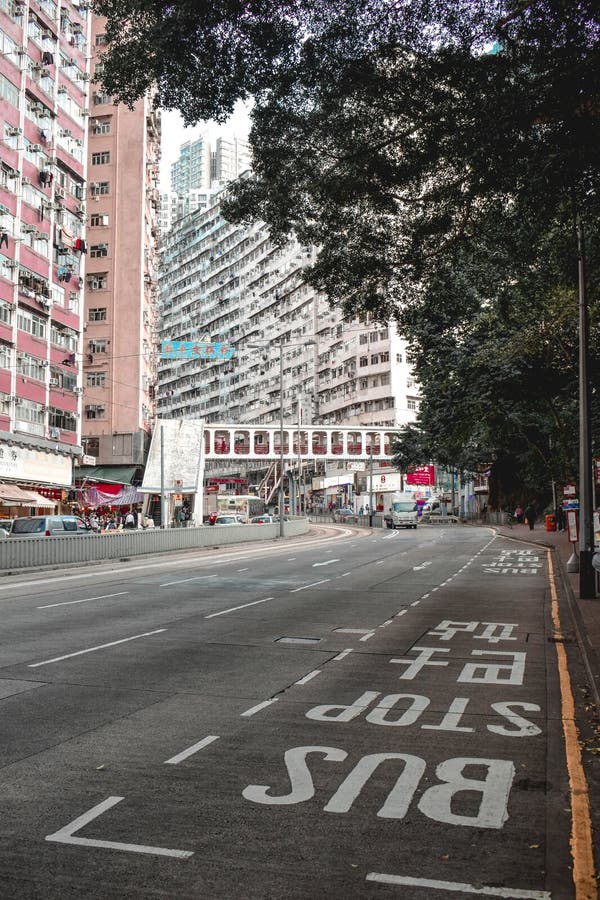 Parada de autobús en una calle vacía en Hong Kong con el edificio residencial grande en el fondo imagen de archivo libre de regalías Parada de autobús en una calle vacía en Hong Kong con el edificio residencial grande en el fondo imagen de archivo libre de regalías