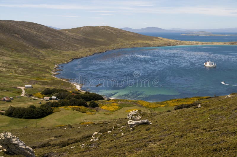An idyllic bay in the Falkland Islands with a farmhouse by the shore and cruise ship anchored nearby. An idyllic bay in the Falkland Islands with a farmhouse by the shore and cruise ship anchored nearby.