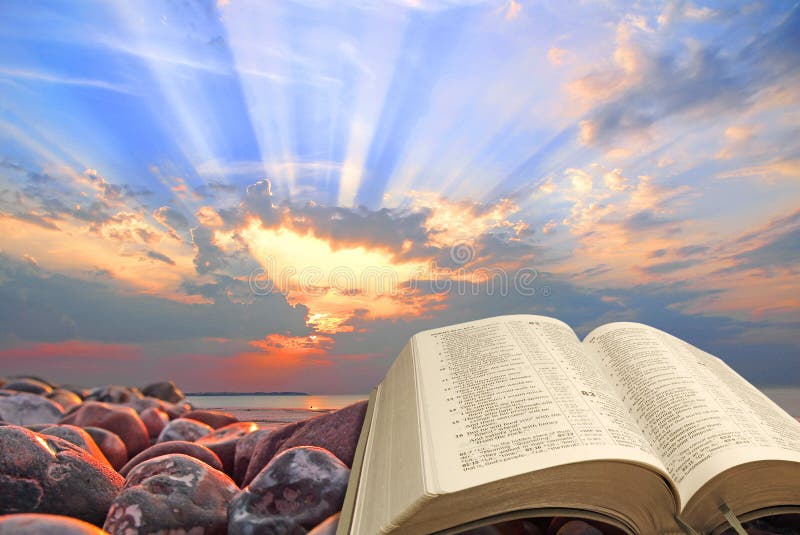 Concept photo of an open holy bible with sun rays in sky depicting divine spiritual light for mankind. Concept photo of an open holy bible with sun rays in sky depicting divine spiritual light for mankind.