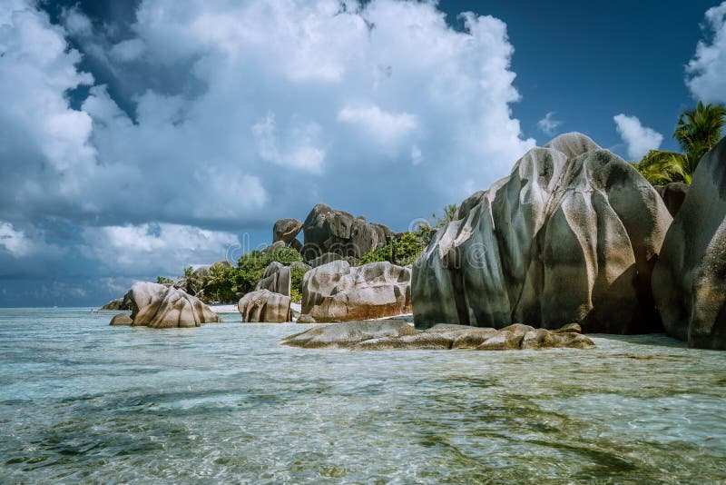 Anse Source d&#x27;Argent - most famous paradise tropical beach. Bizarre granite rocks against beautiful white clouds. La Digue island, Seychelles. Anse Source d&#x27;Argent - most famous paradise tropical beach. Bizarre granite rocks against beautiful white clouds. La Digue island, Seychelles.