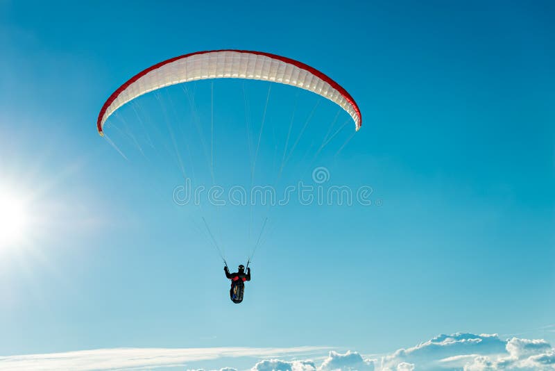 Paraglider Flying Over The Clouds Into The Sun Stock Image Image of