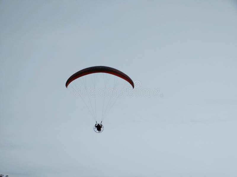 Padákový kluzák létání na padáku při západu slunce na louce.