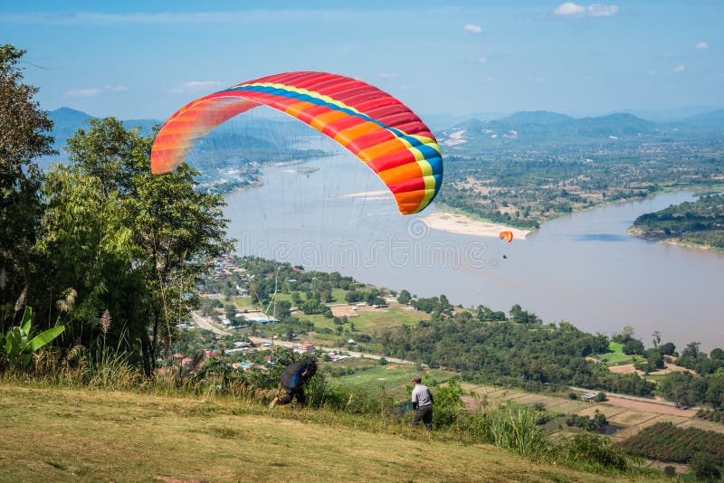 Paragliding sport. Person som utövar paraglidering som flyger över Mekong-floden, utomhusäventyr