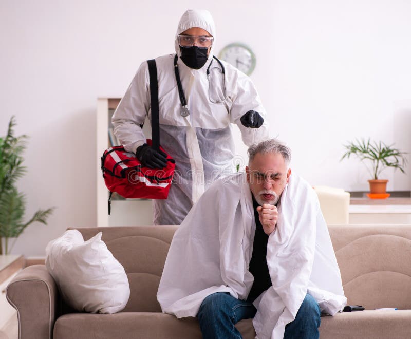 Paramedic tânăr care vizitează un bătrân acasă stock image