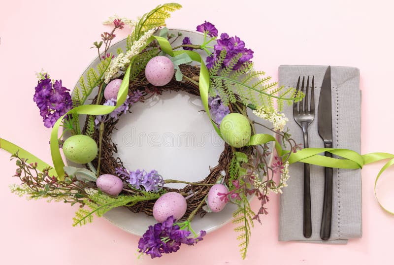 Paramètre de table de pâques. couleur pastel oeuf et couronne de fleurs et couverts en rose