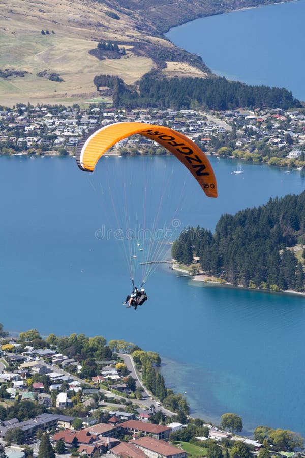 Queenstown, New Zealand - March 2016: Tandem paragliding over Lake Wakatipu in Queenstown, New Zealand. Queenstown, New Zealand - March 2016: Tandem paragliding over Lake Wakatipu in Queenstown, New Zealand