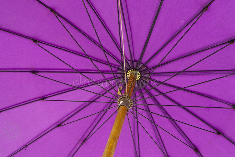 Close-up on the underneath of a purple umbrella with wooden handle. Close-up on the underneath of a purple umbrella with wooden handle