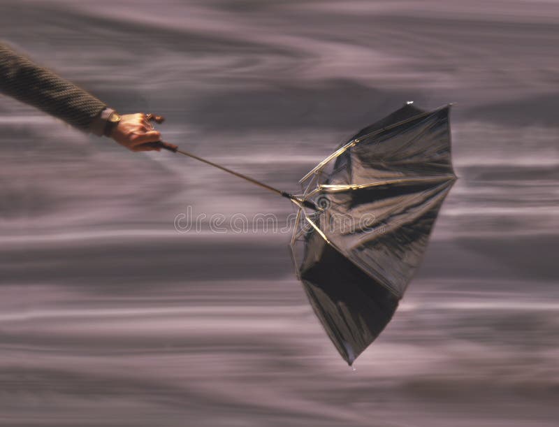 Parapluie de fixation d'homme en vent images stock Parapluie de fixation d'homme en vent images stock