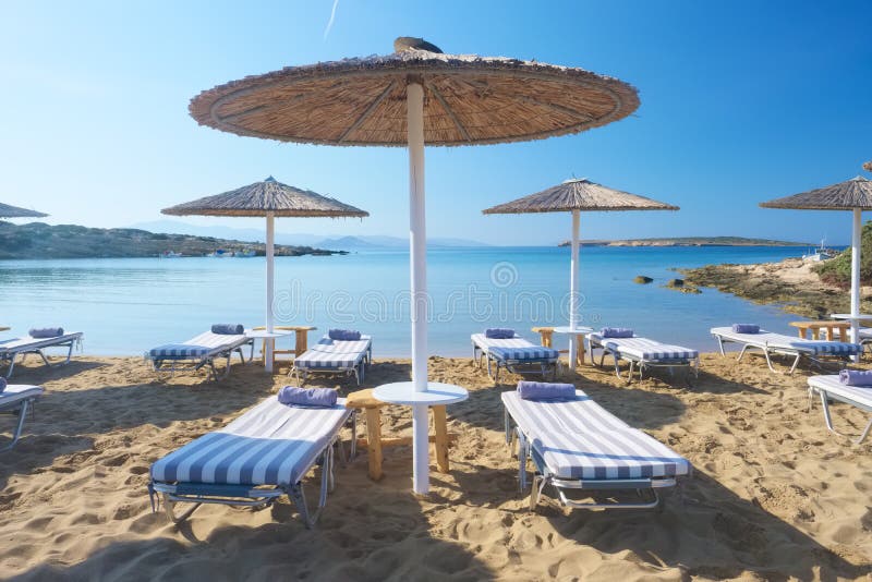 Parapluies avec des lits pliants sur la belle plage sablonneuse avec l'eau de mer de turquoise images libres de droits Parapluies avec des lits pliants sur la belle plage sablonneuse avec l'eau de mer de turquoise images libres de droits
