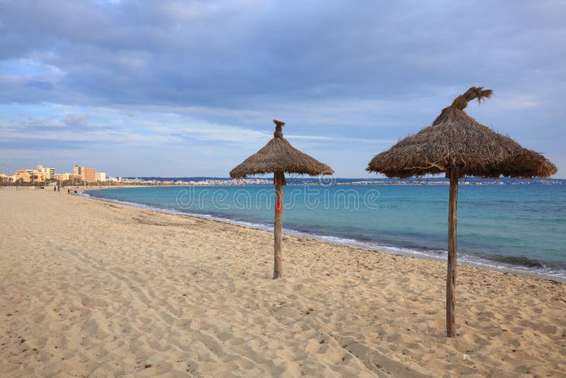 Grass umbrellas on the white sandy beaches of the island of Mallorca, Spain. Grass umbrellas on the white sandy beaches of the island of Mallorca, Spain.