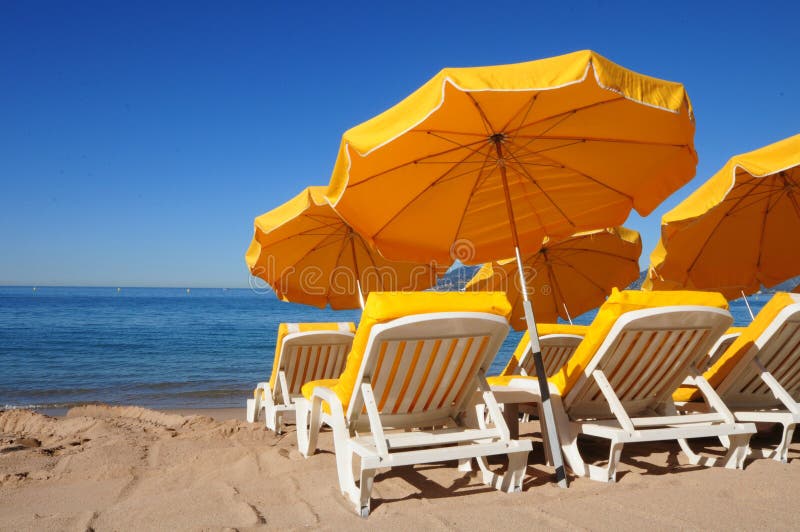 Parapluies jaunes lumineux sur une plage de sable image stock