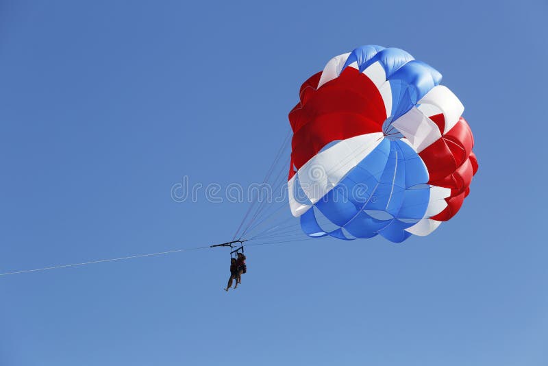 PUNTA CANA, DOMINICAN REPUBLIC - JANUARY 3: Parasailing in a blue sky in Punta Cana on January 3, 2014. Parasailing is a popular recreational activity among tourists in Dominican Republic. PUNTA CANA, DOMINICAN REPUBLIC - JANUARY 3: Parasailing in a blue sky in Punta Cana on January 3, 2014. Parasailing is a popular recreational activity among tourists in Dominican Republic