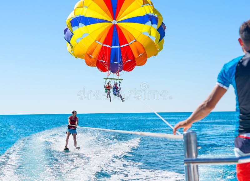 Parasailing feliz de los pares en playa Dominicana en verano Pares u imagen de archivo libre de regalías Parasailing feliz de los pares en playa Dominicana en verano Pares u imagen de archivo libre de regalías