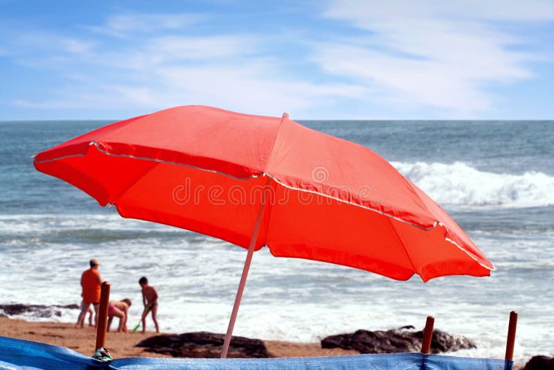 Beach umbrella with people close to the sea. Beach umbrella with people close to the sea