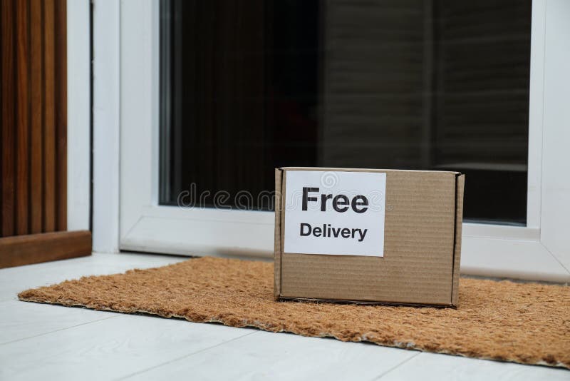 Parcel with Sticker Free Delivery on Rug. Courier Service Stock Photo