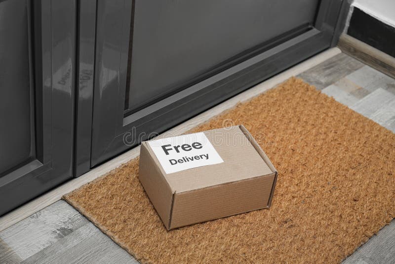 Parcel with Sticker Free Delivery on Rug. Courier Service Stock Image