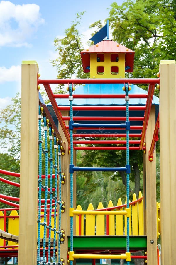 Parco giochi di un castello nuovo e colorato con cornice in arrampicata e scala di corde per bambini immagine stock