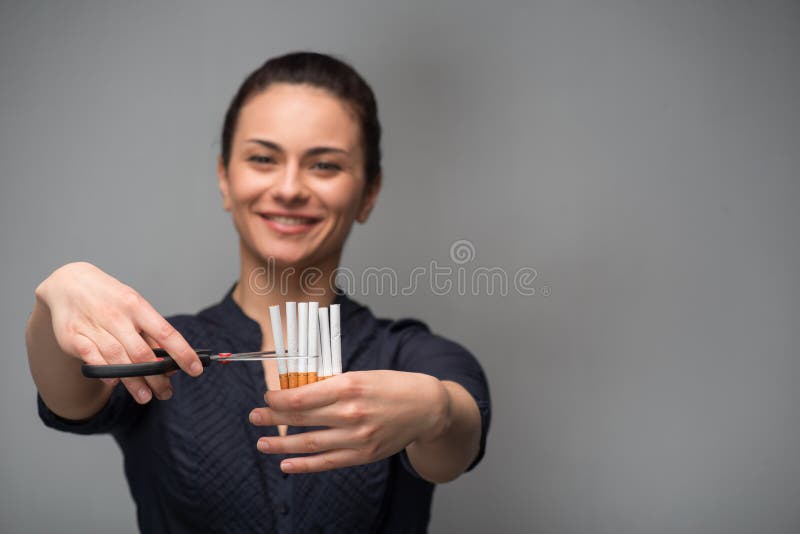 Pare de fumar o conceito Cigarros do corte da jovem mulher imagens de stock royalty free Pare de fumar o conceito Cigarros do corte da jovem mulher imagens de stock royalty free