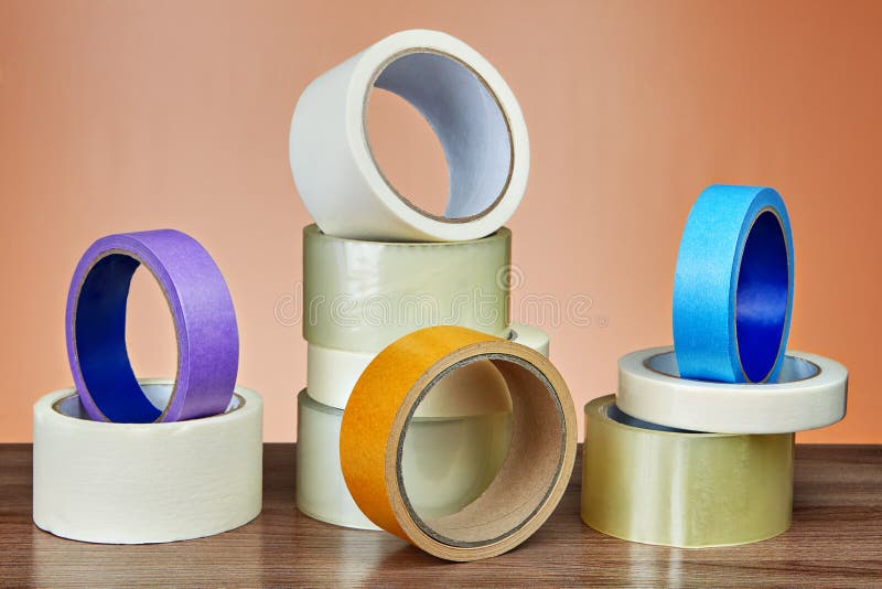 Parecchi rotoli del nastro adesivo per scopi diversi sulla tavola fotografia stock libera da diritti Parecchi rotoli del nastro adesivo per scopi diversi sulla tavola fotografia stock libera da diritti