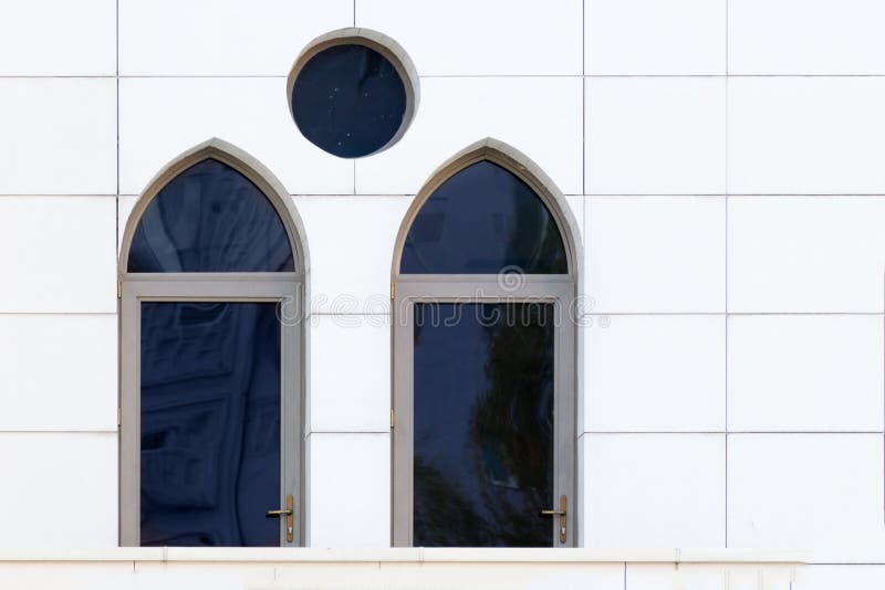 Pared blanca con las ventanas arqueadas y redondas, detalle del exterior constructivo fotografía de archivo libre de regalías Pared blanca con las ventanas arqueadas y redondas, detalle del exterior constructivo fotografía de archivo libre de regalías