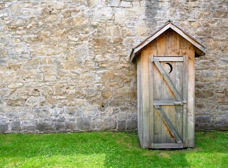 Image of a rustic outhouse with a vintage stone wall. Image of a rustic outhouse with a vintage stone wall