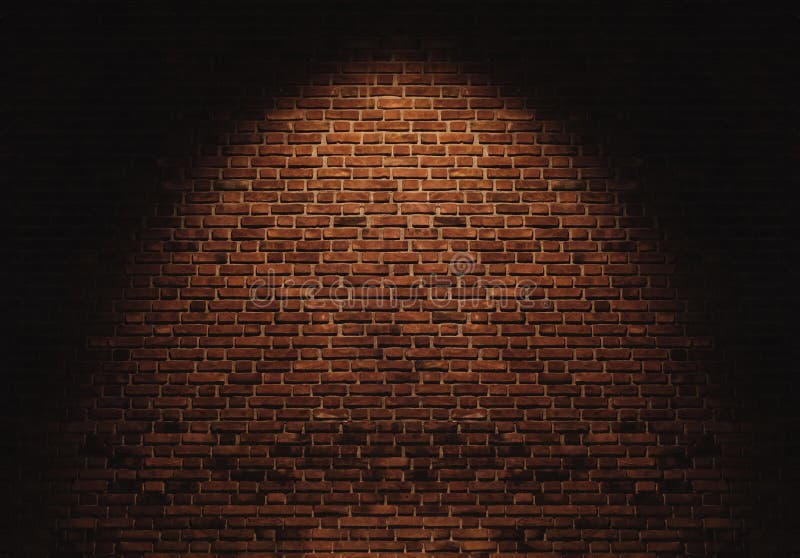 Parede de tijolos com um foco de luz no centro do fundo fotos de stock