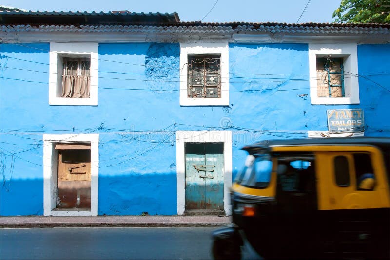Paredes azules de casas y de la falta de definición de movimiento históricas rápidamente de conducir el carrito indio foto de archivo libre de regalías Paredes azules de casas y de la falta de definición de movimiento históricas rápidamente de conducir el carrito indio foto de archivo libre de regalías