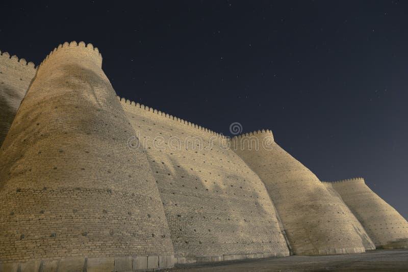 Paredes da cidade da cidade antiga de Bukhara em Usbequistão, na noite estrelado Parede da fortaleza maciça da arca fotografia de stock royalty free Paredes da cidade da cidade antiga de Bukhara em Usbequistão, na noite estrelado Parede da fortaleza maciça da arca fotografia de stock royalty free