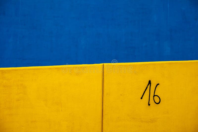 Colored and geometric concrete walls, blue, yellow and number 16. Details of concrete buildings. Backgrounds and textures. Industrial art and city. Colored and geometric concrete walls, blue, yellow and number 16. Details of concrete buildings. Backgrounds and textures. Industrial art and city