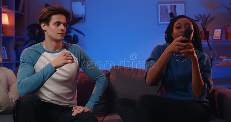 Pareja de adultos milenarios peleando por control remoto y ganando y eligiendo canal. novio joven metrajes