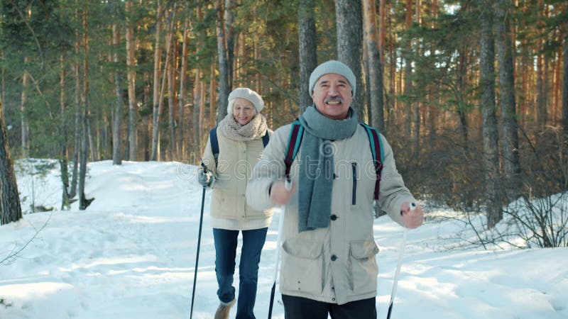 Pareja de ancianos activa ocupada con caminar nórdico en el parque disfrutando de hacer ejercicio al aire libre