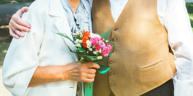 Pareja de ancianos camina por el parque verde. abuela y abuelo en la celebración del aniversario de su boda de oro. cincuenta años imágenes de archivo libres de regalías
