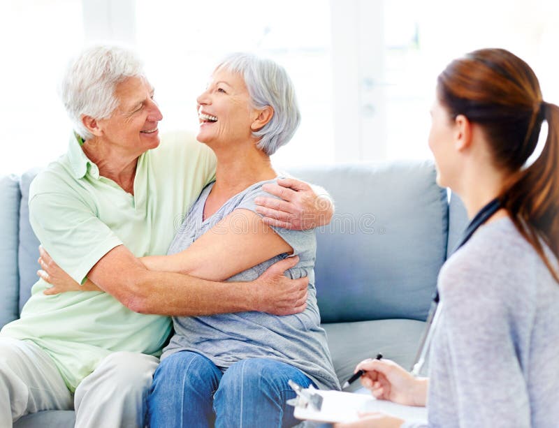 Pareja de ancianos felices y abrazarse en el sofá en la residencia con un buen médico de noticias o resultados positivos. los viej imagenes de archivo