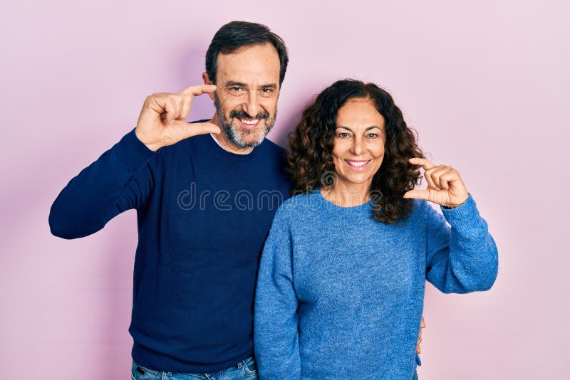 pareja-de-mujeres-hispanas-mediana-edad-abrazando-y-parados-juntos-sonriendo-gestos-confiados-con-la-mano-haciendo-peque%C3%B1os-dando-245636517.jpg