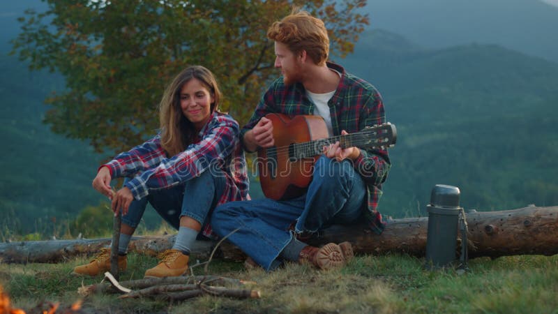 Pareja de viajeros de closet se relajan en viaje de montaña. los acampados disfrutan de la música romántica. metrajes