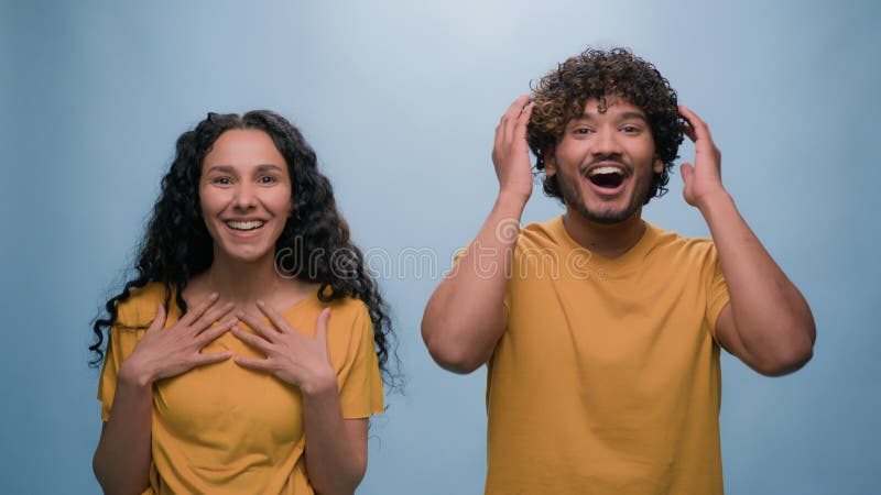 Pareja divertida sorprendida por el retrato de fondo de estudio azul hispano latino hispano y hombre arabio indio sorprendido de b