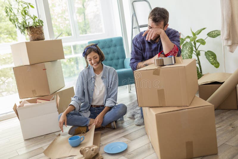 Pareja embalando cosas mientras se muda casa imagenes de archivo
