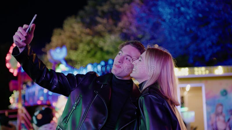 Pareja encantadora se toma selfie en el parque de atracciones .