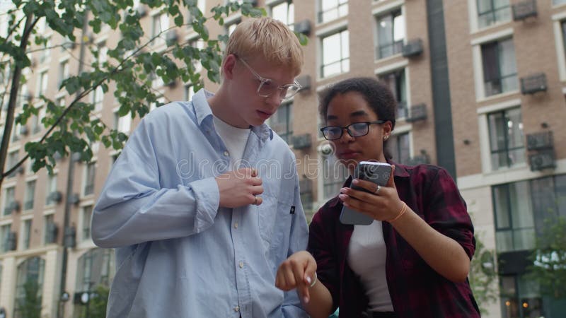Pareja joven discutiendo mientras usa un smartphone almacen de video