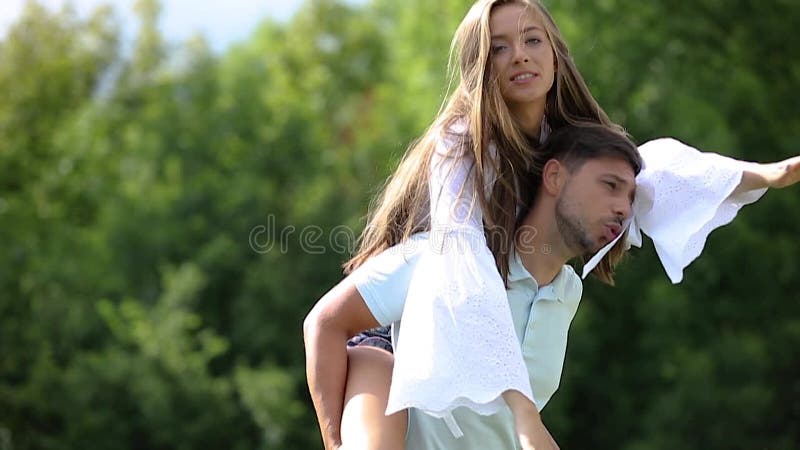 Pareja joven riendo y divirtiéndose juntos en la naturaleza almacen de metraje de vídeo