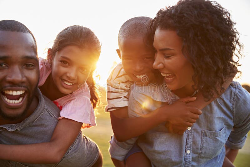 Pareja negra joven que disfruta de tiempo de la familia con los niños imagen de archivo