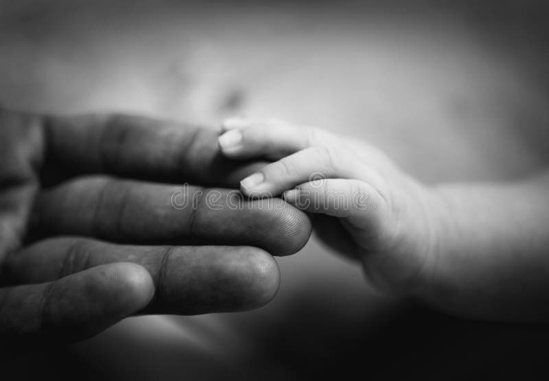 Parent holding newborn baby hand