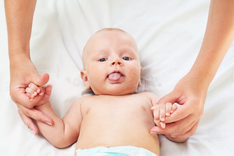 The parent holds for hands of the baby