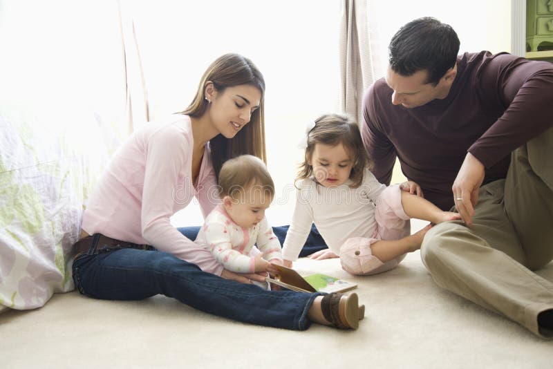 Caucásico una mujer madre a sobre el dormitorio piso mira a un libro.