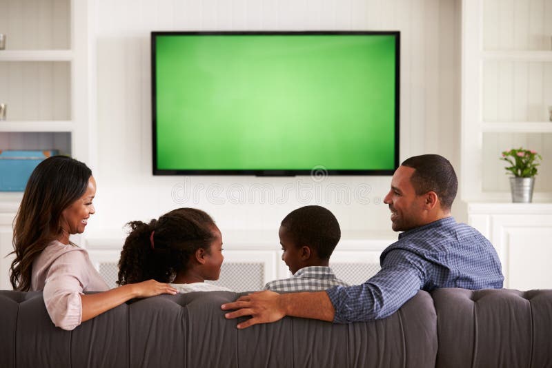 Parents et enfants regardant la TV, regardant l'un l'autre